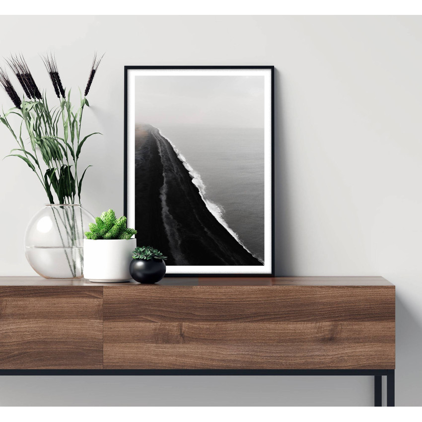 Svartvitt fotografi av strand med skummande vågor